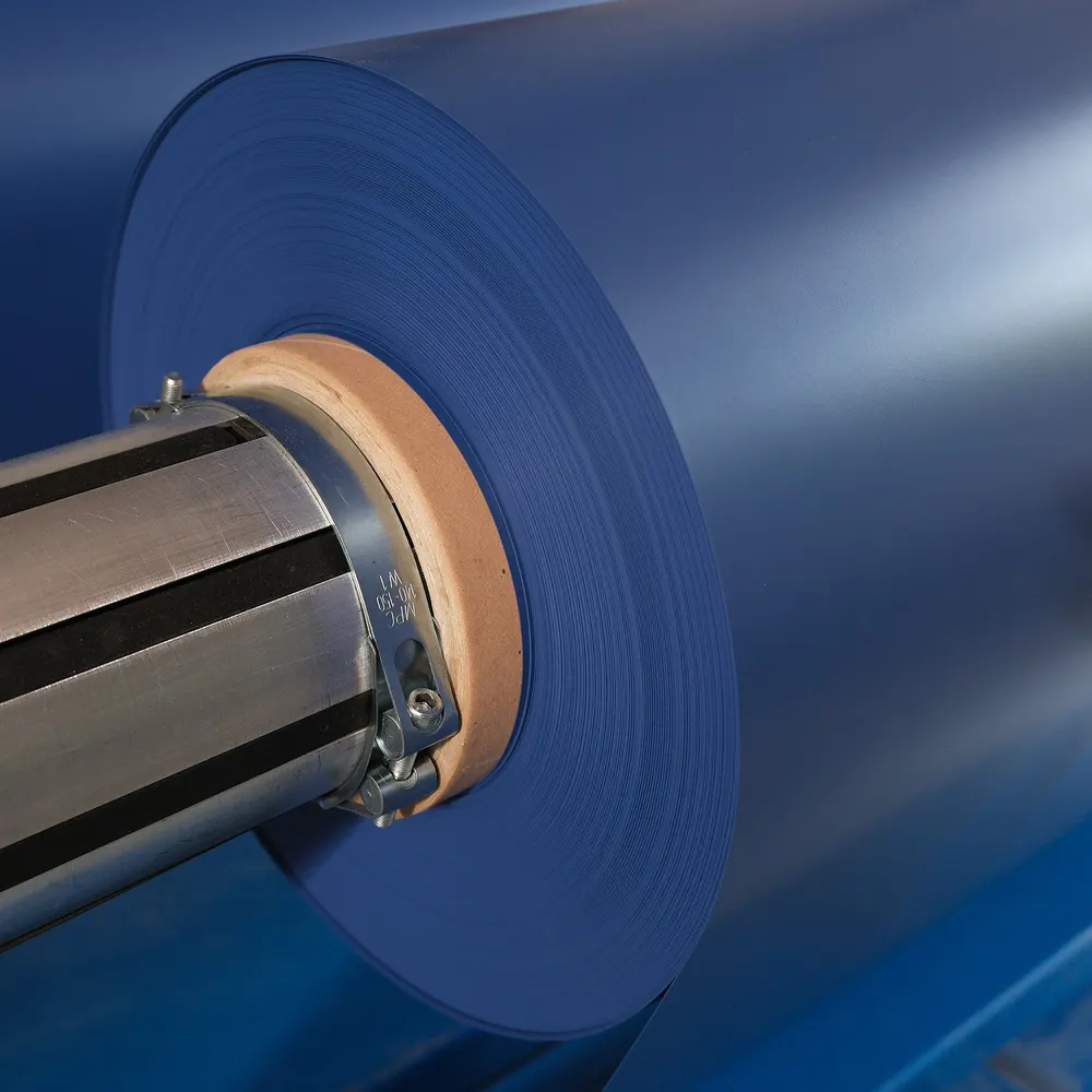 A roll of blue vinyl on a steel shaft in AKVA’s production