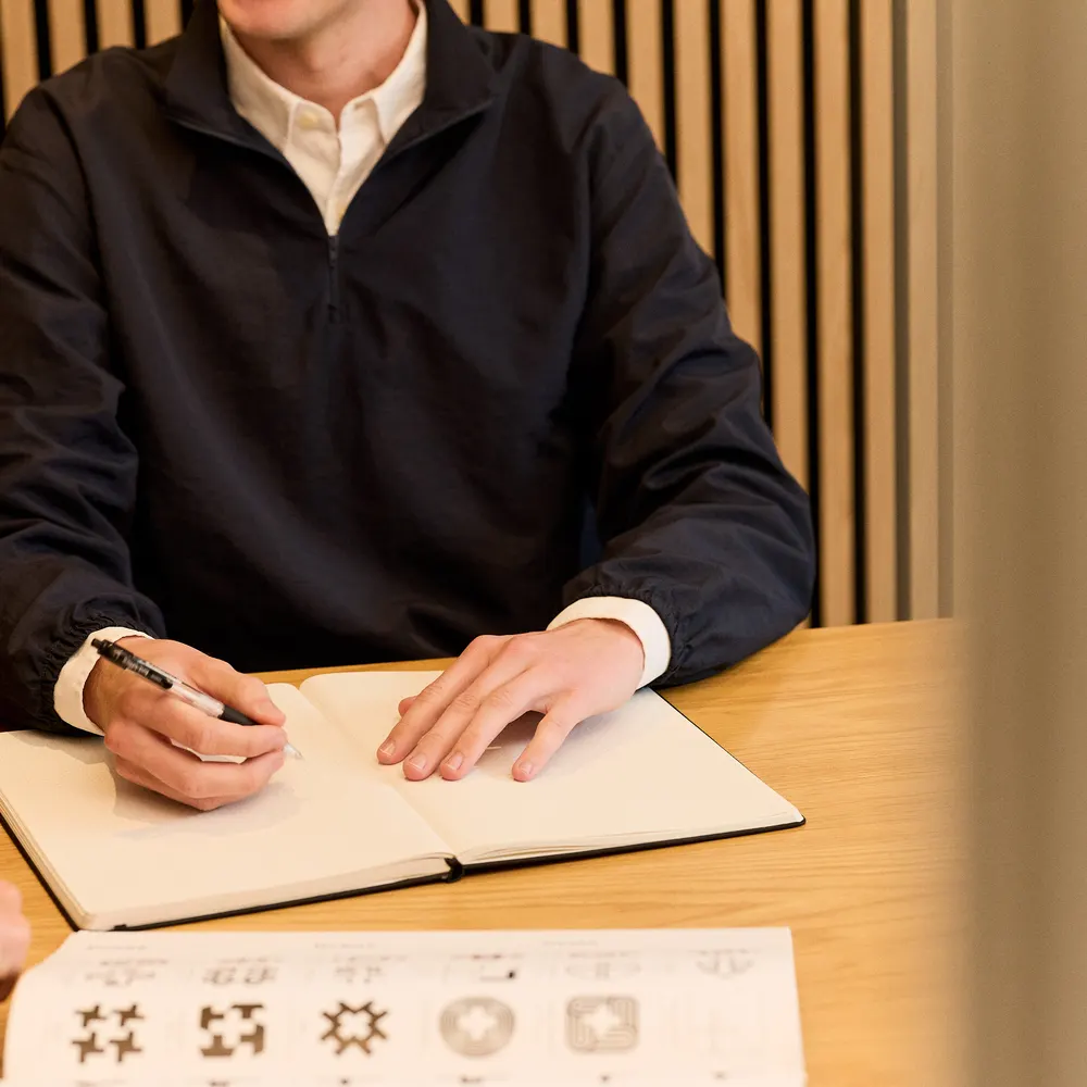 Christian writing in a notebook at a table