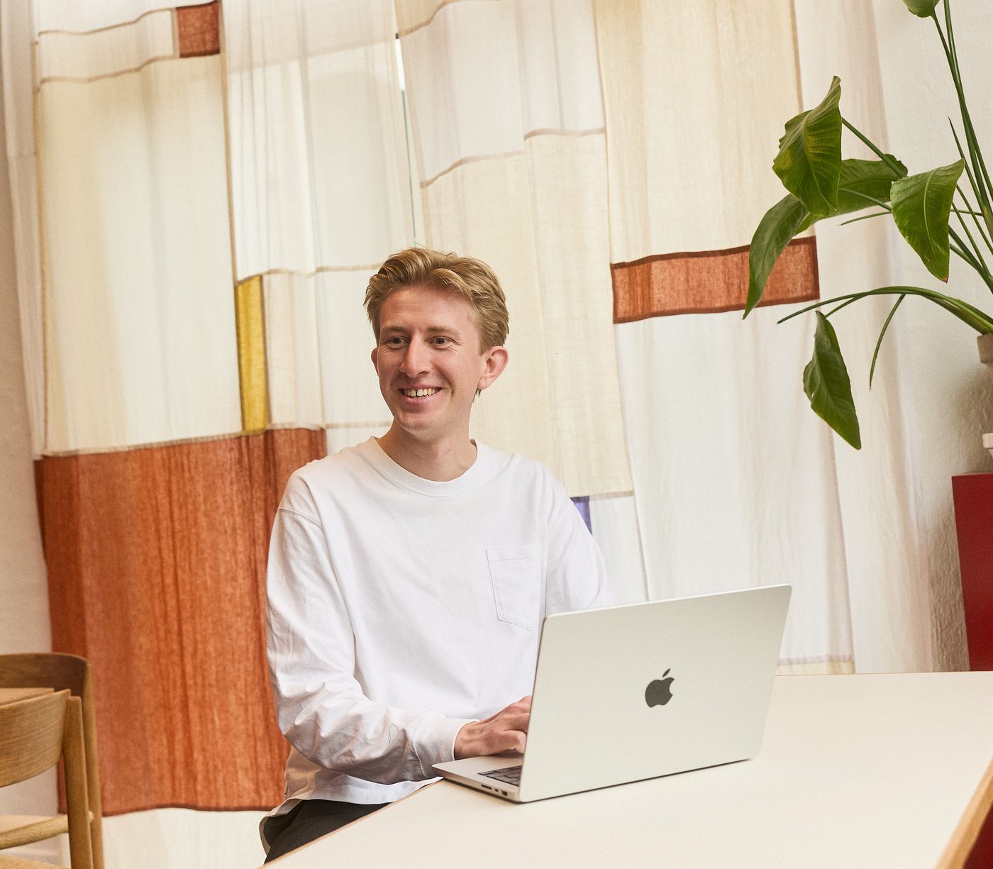 Christian Toft Bach ved arbejdsbordet foran et vævet tekstil