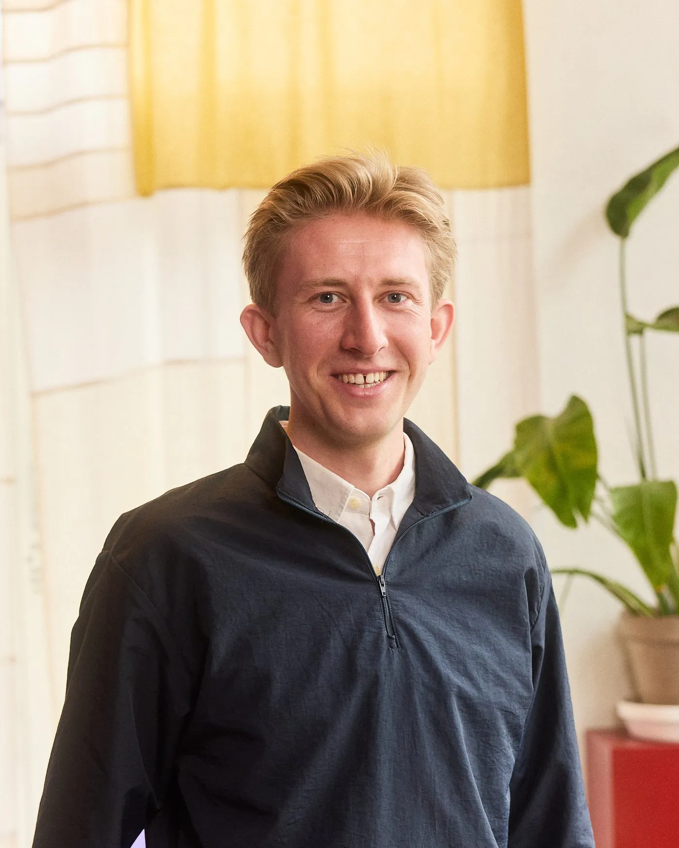 Christian Toft Bach in front of a woven textile in yellow and sand